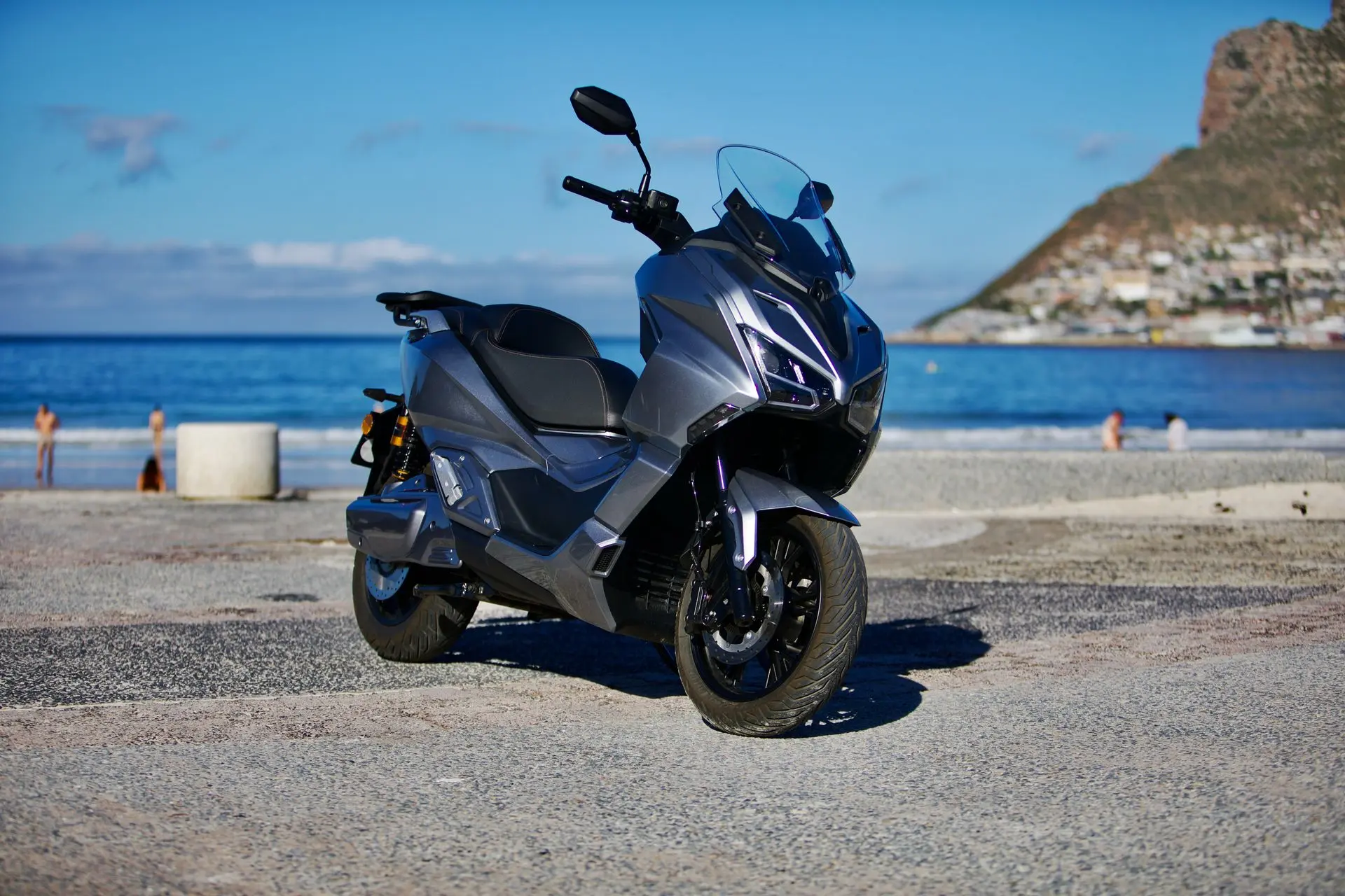 EWIZZ LIGHTNING Mk2 electric motorcycle at the beach with the mountains behind